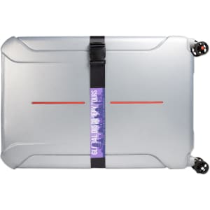 A silver suitcase secured with a black luggage strap, featuring a colorful logo.