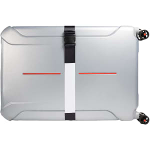 A luggage strap secures a silver suitcase, featuring a minimalistic design with a central white stripe and red accents.