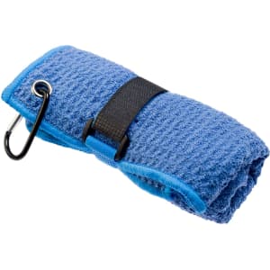 A blue travel towel is neatly rolled and secured with a black strap, featuring a carabiner for attachment.
