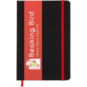 A black A5 notebook with a red elastic band and branding on the front cover.