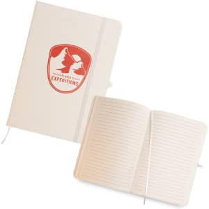 A cream A5 notebook with a logo, featuring lined pages and a ribbon bookmark. The cover has a textured finish.