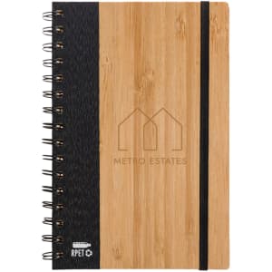 A spiral-bound notebook with a bamboo cover and a dark fabric section, featuring a logo.