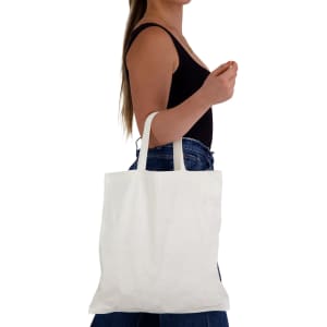 A person holding a plain white short handle bamboo tote bag, with a simple design and one logo visible.