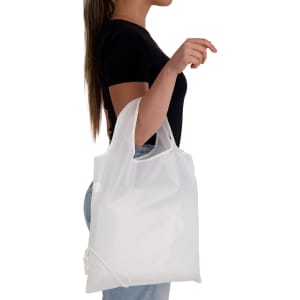 A white reusable shopping bag is held by a person, displaying a simple design and shoulder straps.