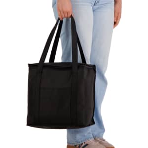 A black cooler bag with dual handles, held by a person wearing light blue jeans. It features a simple design and has a logo.