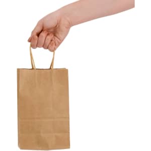A small brown paper bag with gold handles, held by a hand. The bag has a smooth texture.