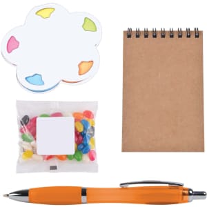 An orange pen, a notepad, colorful sticky notes, and a bag of assorted jelly beans in a gift set.