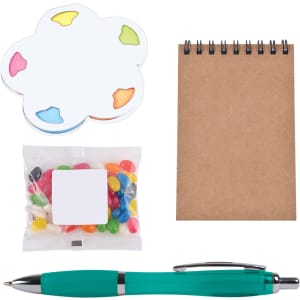 A colorful sticky note pad in a flower shape, a small bag of jelly beans, a spiral-bound notepad, and a turquoise pen.