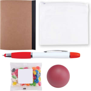 A brown notebook, a clear pouch, a red and white pen, a red stress ball, and a bag of colorful jelly beans.