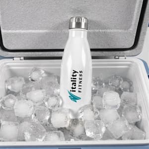 A drink bottle in white with a silver cap, nestled among ice cubes in a cooler, featuring a logo.