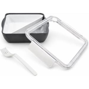 A square, black and white lunch box with a clear lid and a white fork. The lid has a vent.
