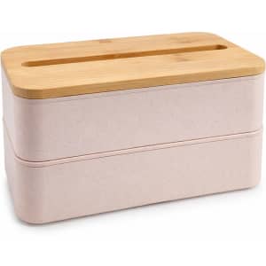 A pink eco lunch box with a bamboo lid features a phone holder slot on top. It has a sleek, stacked design.