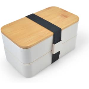 A two-tiered lunch box in white with a bamboo lid, secured by a black elastic band and featuring a branded logo.