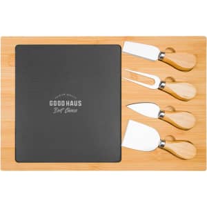 A bamboo cheese board with a black slate section and four stainless steel cheese knives with bamboo handles.