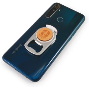 A drink bottle opener and phone stand in silver, attached to a dark blue smartphone, featuring a logo on the opener.
