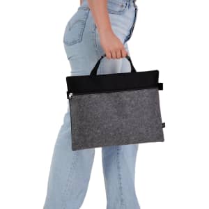 A grey felt satchel with a black top, featuring handles and a zipper, being held by a person.