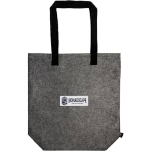 A gray tote bag with black handles featuring a printed logo label that reads "NOMADSCAPE."