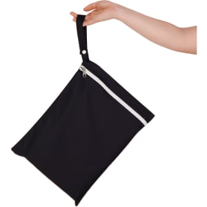 A black wet bag with a white zip, held by a hand, featuring a looped handle for easy carrying.