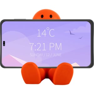 An orange stress reliever shaped like a seated figure, holding a smartphone in a vertical position.