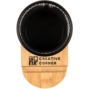 A black pen tidy phone stand with a bamboo base, featuring a logo on the front.