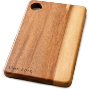 An acacia serving board featuring a natural wood finish with a circular handle and engraved branding.