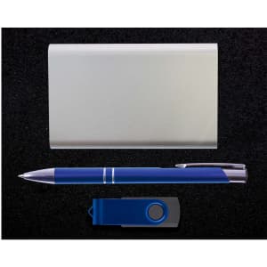 A silver card holder, a blue pen, and a blue USB flash drive arranged against a dark background.