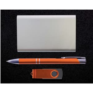 A gift set featuring a sleek silver card holder, an orange pen, and an orange USB flash drive.