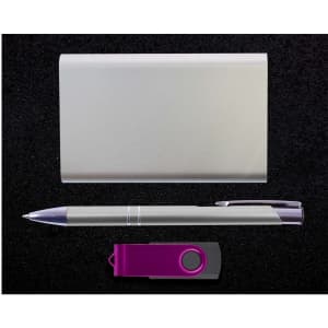 A gift set featuring a sleek power bank, a stylish pen, and a USB flash drive, all presented on a dark background.