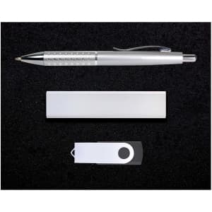 A silver pen, a silver USB drive, and a silver cardholder arranged on a black surface.