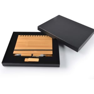 A bamboo notebook with a spiral binding, a bamboo pen, and a USB drive, packaged in a black gift box.