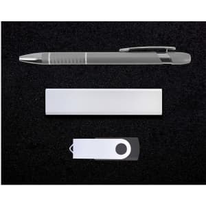 A silver pen, USB drive, and a sleek metallic note holder arranged on a black background.