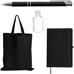 A black tote bag, black pen, sanitizer bottle, and black notebook organized in a promotional product pack.
