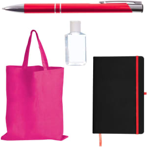 A red pen, a clear bottle of hand sanitizer, a pink tote bag, and a black notebook with an orange elastic band.