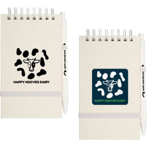 A notepad with a cow-themed design in beige and black, accompanied by a white pen, featuring a logo.