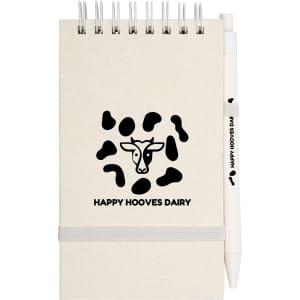A spiral notepad with a tan cover and a pen, featuring a logo and a cow pattern design.