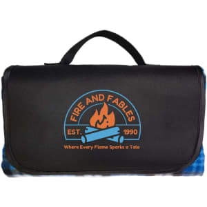 A picnic blanket in black with a logo featuring flames and blue accents. It includes a convenient carrying handle.