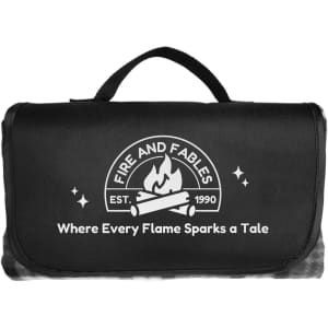 A black picnic blanket with a handle and a logo featuring flames and text.