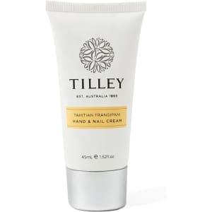 A hand and nail cream tube in white and silver, featuring a floral logo and a yellow label.