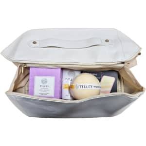 A cream-coloured bag contains various Tilley products, including soap and skincare items in purple and white packaging.