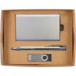 A gift set featuring a silver card holder, a silver pen, and a silver USB drive, all presented in a cardboard box.