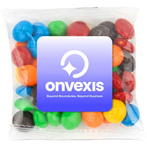 A clear pouch containing colourful chocolate-coated candies in red, blue, green, yellow, and brown. It has a logo on the front.