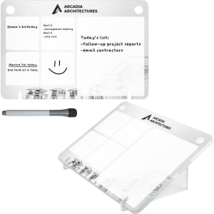 A transparent desk planner featuring sections for notes and reminders, with a black marker. It has a logo and is sleek in design.