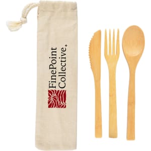 A bamboo cutlery set in a calico pouch, featuring a knife, fork, and spoon. The pouch has a logo.