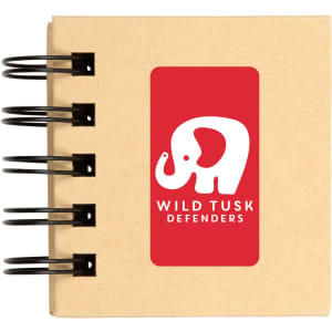 A spiral-bound notebook with a kraft cover featuring a white elephant logo and the text "WILD TUSK DEFENDERS."