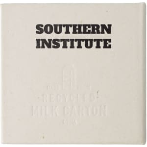 A square, off-white note block made from recycled materials, featuring a logo and embossed text.
