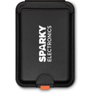 A black Cozy Phone Wallet with a logo, featuring a secure closure and a contrasting orange accent.