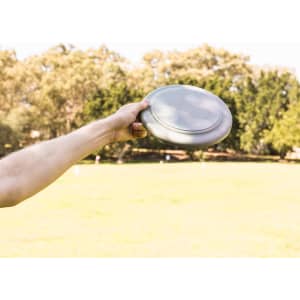 A frisbee is being held in a hand, featuring a sleek, circular design.