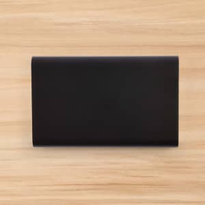 A sleek black Octavius 8,000mAh Power Bank is displayed on a wooden surface.