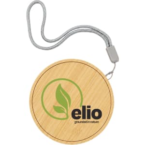 A bamboo wireless charger with a circular design and a silver strap, featuring a logo on the surface.