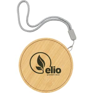 A round bamboo wireless charger with a grey strap and an embossed logo.
